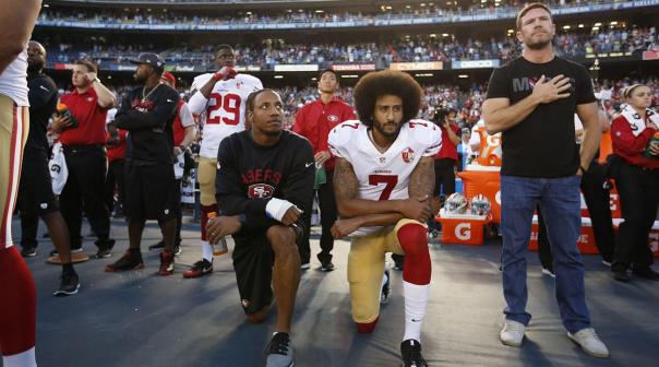 NFL teammates Eric Reid and Colin Kaepernick kneel next to former football player and Army Green Beret Nate Boyer, who suggested kneeling as a form of respectful protest